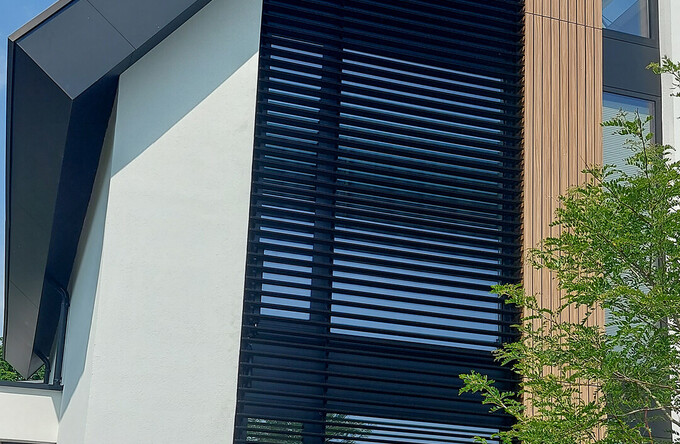 Trapezförmige Fenster, die bis zum Dachfirst reichen sind ausgestattet mit kippbaren Lamellen
